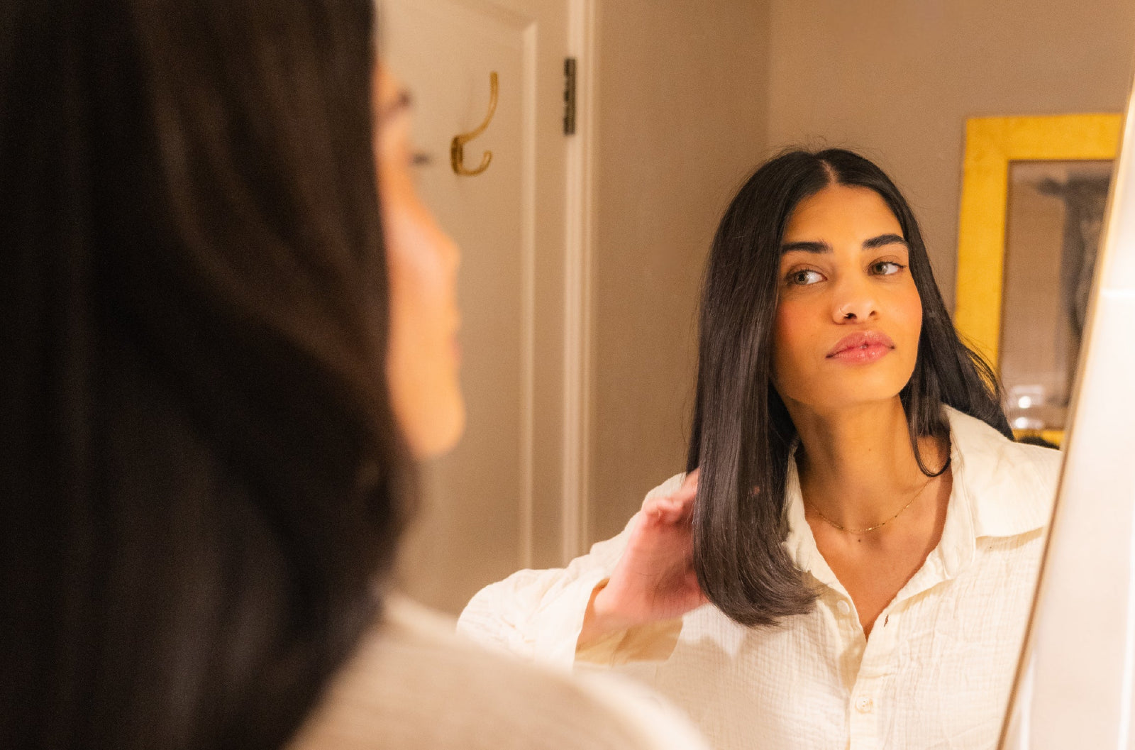 woman with long bob haircut looking in the mirror