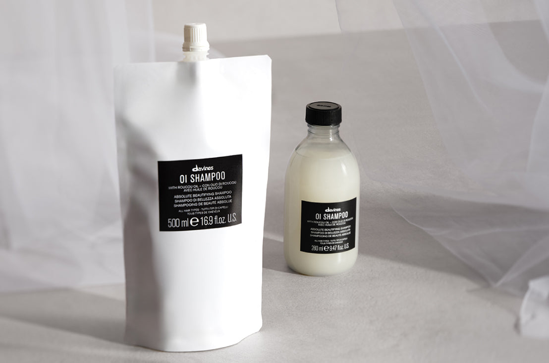 Davines OI Shampoo Refill Pouch next to the regular sized OI Shampoo